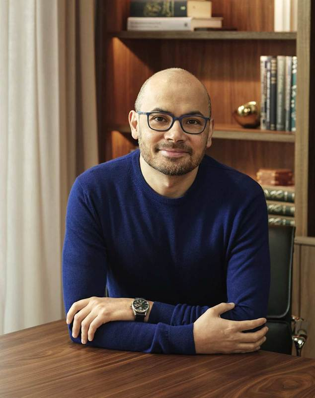 A professional seated figure suggesting intellectual engagement and leadership in a warm, book-lined study setting.  Image Credit: Sir Demis Hassabis, CEO of Google DeepMind and Nobel Prize winner - Creative Commons licensed